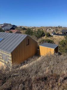 een gebouw bovenop een heuvel naast een veld bij HS001-Henne-Enebaervej-6 in Henne Strand