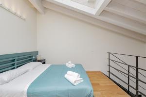Un dormitorio con una cama azul con toallas. en BG Center, en Bérgamo