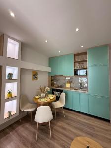 a kitchen with blue cabinets and a table and chairs at Lemon Garden Cozy 2BR Apt Private Garden Center in Tirana