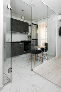 cocina con mesa y pared de cristal en Escape Hub Residence Militari 2, en Chiajna
