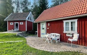 a red house with a table and chairs in front of it at 3 Bedroom Cozy Home In Brunskog in Vikene