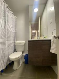 a bathroom with a toilet and a sink and a mirror at Precioso departamento amueblado 2 habitaciones + 2 baños in Los Ángeles