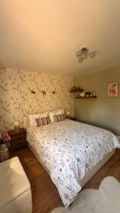 1 dormitorio con 1 cama grande y papel pintado con motivos florales en Cozy Apartment, en Londres