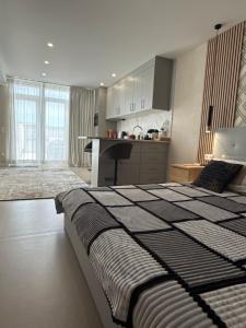 a bedroom with a large bed and a kitchen at Casa Juli Cascais in Alcabideche
