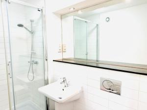 カンタベリーにあるLovely Studio at Canterbury City Centreの洗面台とシャワー付きの白いバスルーム