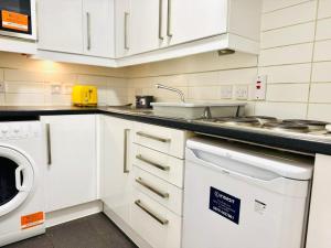 カンタベリーにあるLovely Studio at Canterbury City Centreの白いキャビネットと食器洗い機を備えたキッチン +6枚の写真