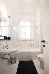 a white bathroom with a sink and a toilet at B&B Pescarenico in Lecco