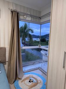 Una habitación con puerta corredera de cristal con vistas a la piscina. en Apartamento praia da Ribeira 2 quartos, en Angra dos Reis