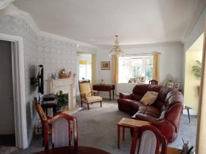 a living room with a leather couch and a fireplace at Semi Rural 3 Bed, loads of space in Pontypridd