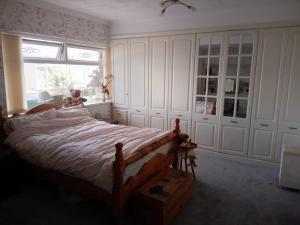 a bedroom with a bed with a teddy bear sitting on it at Semi Rural 3 Bed, loads of space in Pontypridd