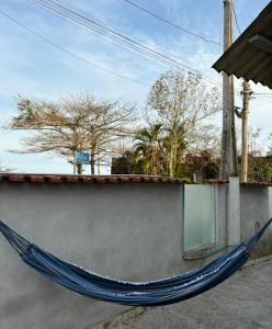 - un hamac bleu sur le côté du bâtiment dans l'établissement Casa Beira Mar - Vista do Mar pela Janela da Sala, perfeita, em frente à praia da enseada Sesc Bertioga, à Bertioga