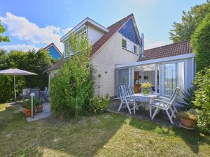 a patio with a table and chairs in a yard at Aan de oever in Stevensweert
