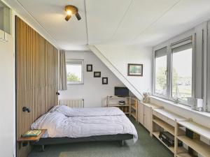 a bedroom with a bed and a staircase at Aan de oever in Stevensweert