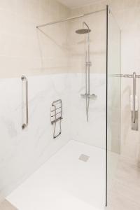 a white bathroom with a shower with a glass door at Hotel Ancla in Oropesa del Mar