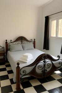 ein Schlafzimmer mit einem Bett mit schwarz-weiß kariertem Boden in der Unterkunft Riad Nahara in Marrakesch