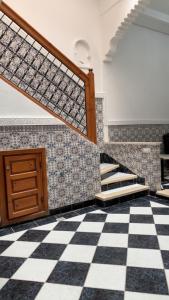 Zimmer mit einem karierten Boden und einer Treppe in der Unterkunft Riad Nahara in Marrakesch