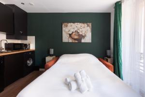 a bedroom with a white bed with two towels at Studio rénové - Accès direct Paris in Montreuil