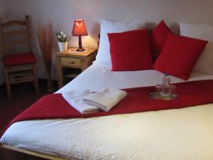 Una cama con dos toallas y una botella. en Maison d'Hôtes Douce Nuit, en Obermodern
