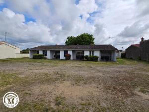 une maison blanche avec une cour devant elle dans l'établissement Gîte 2 pers. proche plages et Marais Poitevin, terrasse couverte, tout inclus - FR-1-426-551, à Saint-Michel-en-lʼHerm