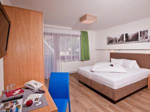 una habitación de hotel con una cama y una mesa con una mesa en Hotel Neuwirt, en Finkenberg