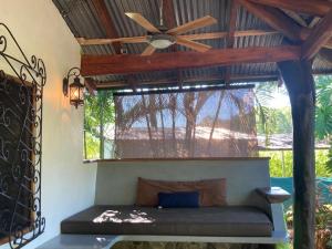 a room with a ceiling fan and a window at Tres Corazones in Carrillo