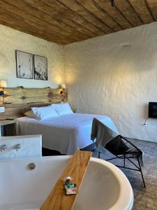 a bedroom with a bed and a bathtub and a bath tub at Pousada do Rei Arthur in Lavras Novas