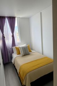 1 dormitorio con 1 cama y una ventana con cortinas moradas en Apto central en BOGOTÁ 2, en Bogotá