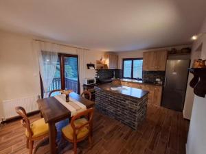 a kitchen with a table and a dining room at Apartments with parking space Trsce, Gorski kotar - 24880 in Tršće