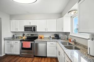 a kitchen with white cabinets and a stove top oven at Family-Friendly Arvada Getaway with Games Galore home in Arvada