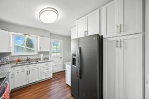 a kitchen with white cabinets and a black refrigerator at Family-Friendly Arvada Getaway with Games Galore home in Arvada +37 photos