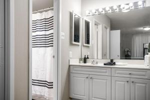 a white bathroom with a sink and a mirror at Stylish 2BR Arlington Near DC Free Parking & Gym in Arlington +24 photos