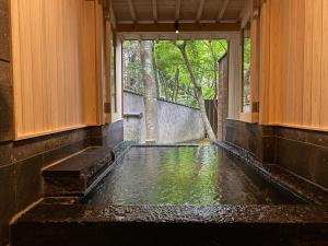 a pool of water in a room with a window at Nihon-no-Ashitaba in Yufu