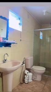 a bathroom with a sink and a toilet and a window at Beira Rio Casa Canastra in Vargem Bonita