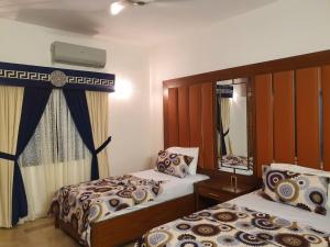 a bedroom with two beds and a window at Hotel Imperial Karachi in Karachi