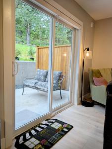 a room with a sliding glass door with a chair and a couch at Oakview Hideaway in Victoria