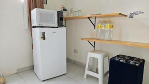 a kitchen with a microwave on top of a refrigerator at Suite 1 - Centro de Convenções700m, AC, WIFI in Recife +17 photos