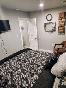 a bedroom with a black and white bed and a door at Red Roof Cottage 2 •hot tub• fire pit• cold plunge in Nampa +47 photos