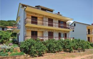 a building with balconies and a garden in front of it at Apartment Jelsa 07 in Jelsa