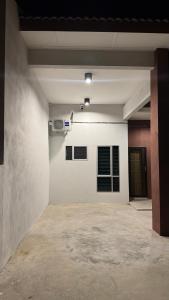 an empty room with a white wall and a window at 122 Segari in Lumut