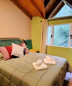 Un dormitorio con una cama grande con dos toallas encima. en Mi Casa Tu Casa B , Departamento centrico, en Lago Puelo