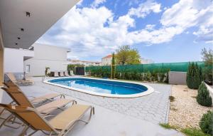 a patio with chairs and a swimming pool at Cozy Home In Kastel Stafilic in Kaštela
