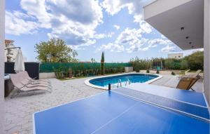 a swimming pool in the backyard of a house at Cozy Home In Kastel Stafilic in Kaštela