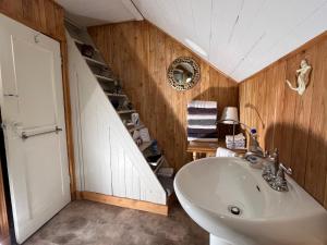 a bathroom with a white sink and wooden walls at La maison du petit rang in Saint-Éloi +21 photos