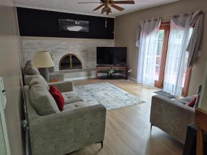 a living room with a couch and a tv at Four Bedroom Family and friends cozy home in Sterling Heights