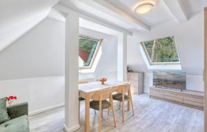 a dining room with a table and two windows at Stunning Apartment In Altenkirchen in Altenkirchen