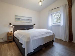 a bedroom with a bed and a window at West barn at Mühlendamm in Steinbergkirche