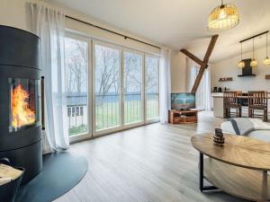 a living room with a fireplace and a couch and a table at East barn at Mühlendamm in Steinbergkirche