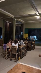 a group of people sitting at tables in a room at Senaru Gateway homestay in Senaru