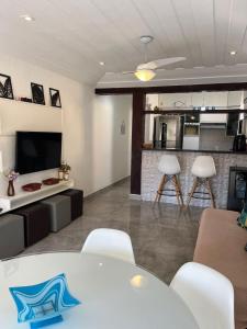 a living room with a table and chairs and a kitchen at Geribá Beach Apart Hotel casa 504 in Búzios +25 photos