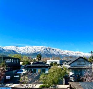 a city with snow covered mountains in the background at Habitación en casa compartida-Sector Los Dominicos in Santiago